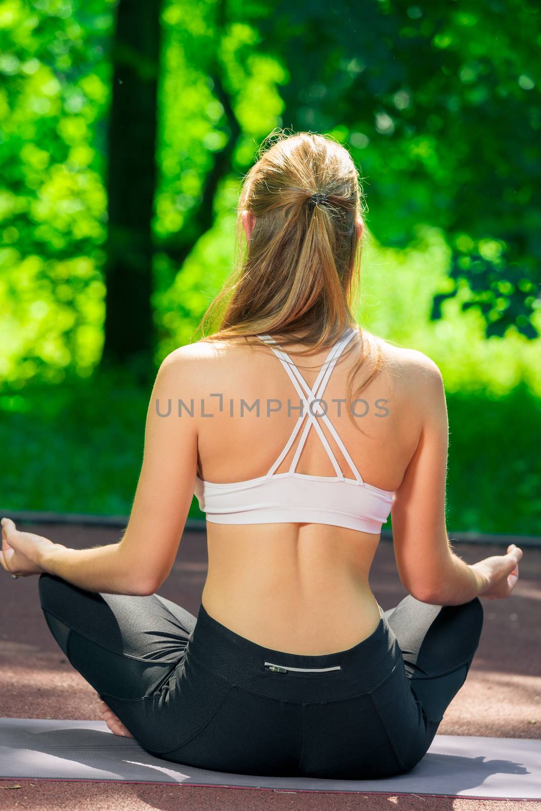 simple yoga asanas - trainer in lotus position view from the bac by kosmsos111