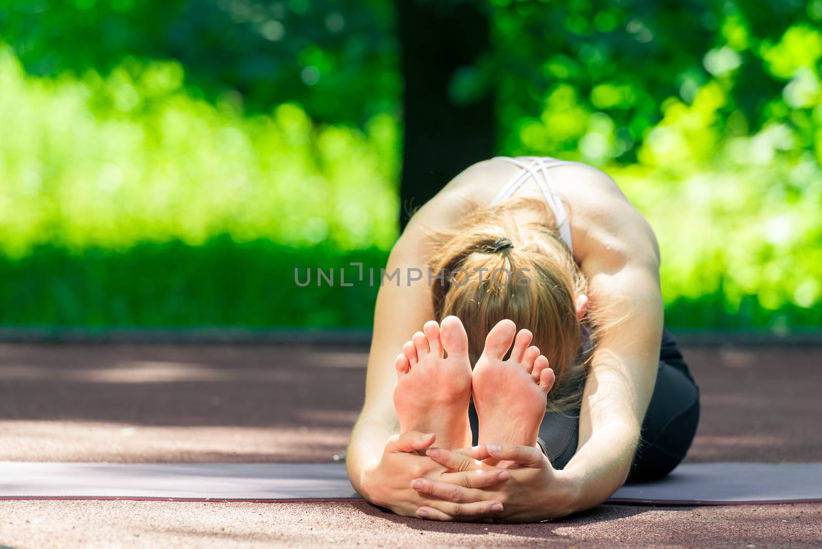 flexible yoga trainer during stretching, summer outdoor exercise by kosmsos111