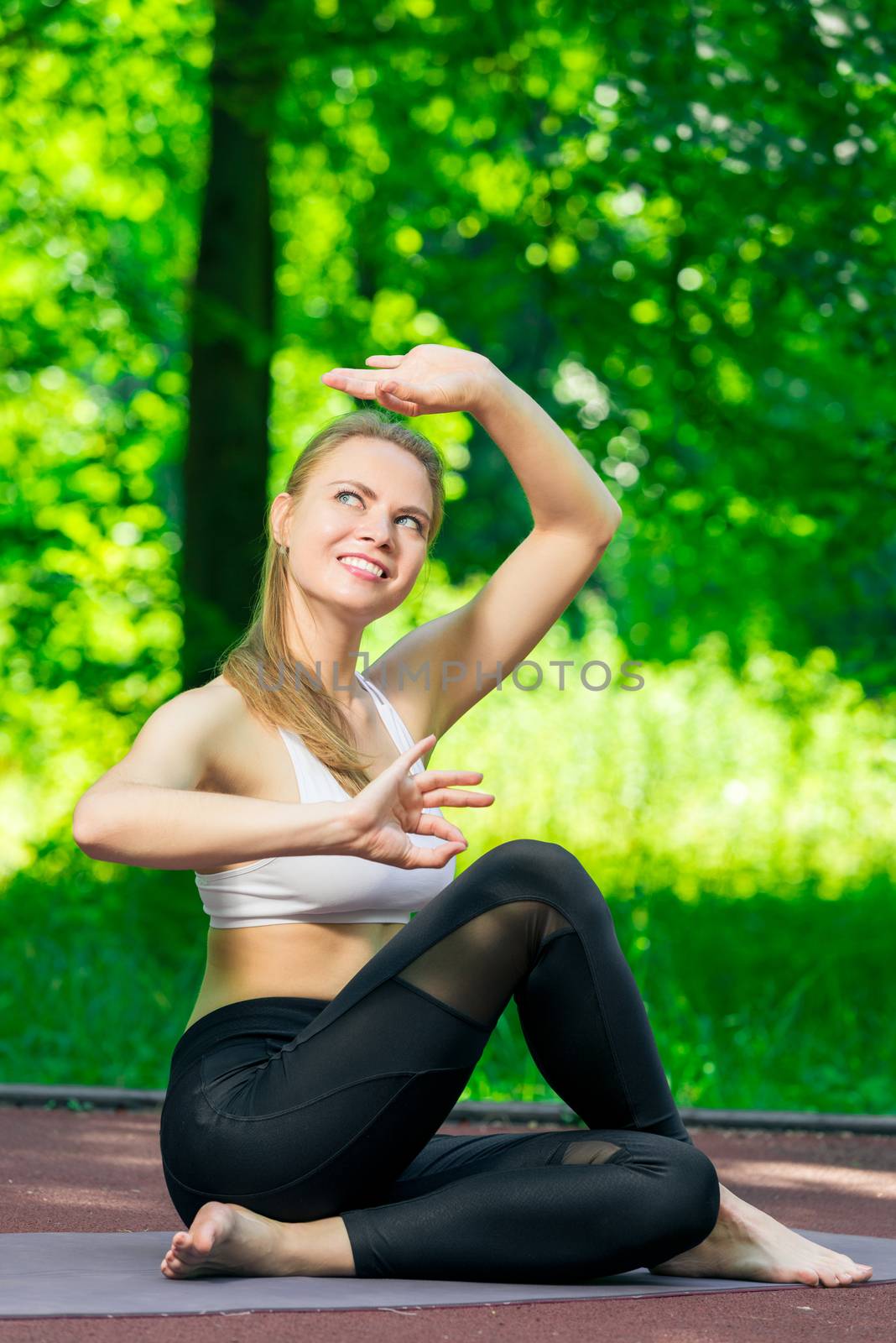 yoga asanas - pilates and yoga trainer performs exercises in the by kosmsos111