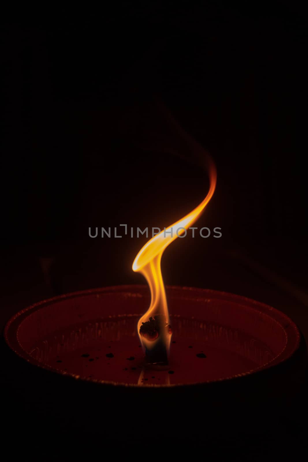 Candle flame close up on dark background, interesting flame figure, candle fire shape like alien head