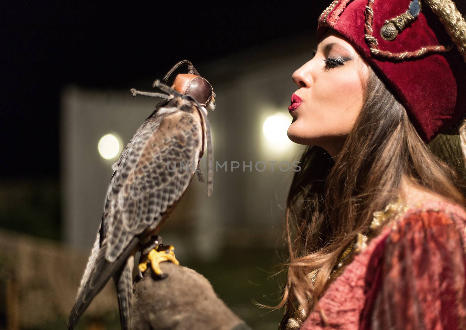 medieval woman holding a falcon on his arm. the lady sends a kiss to the hawk