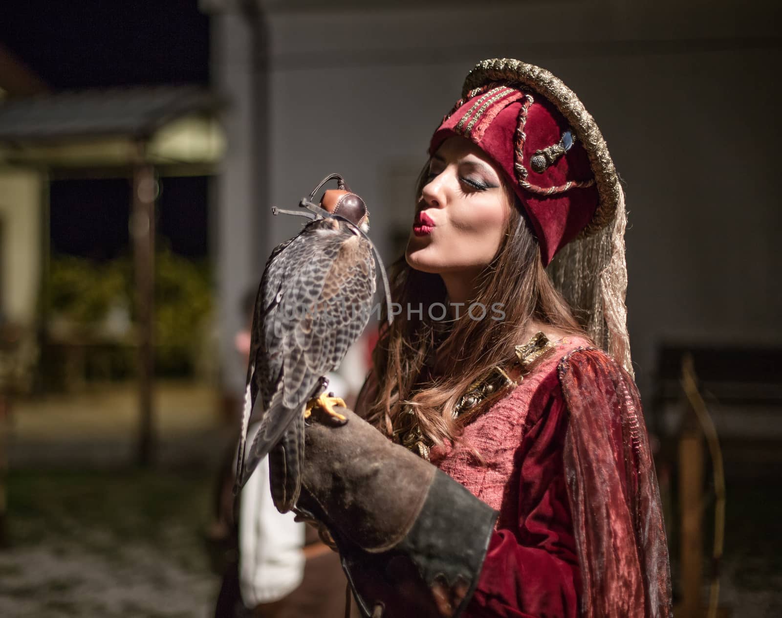 medieval woman holding a falcon on his arm. the lady sends a kiss to the hawk