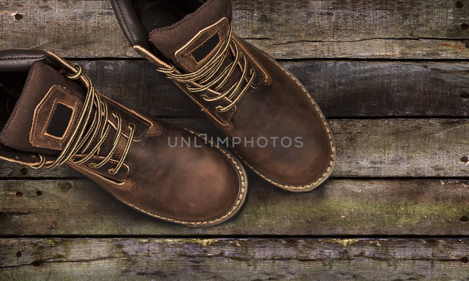Brown men's boots, on a wooden background by SlayCer