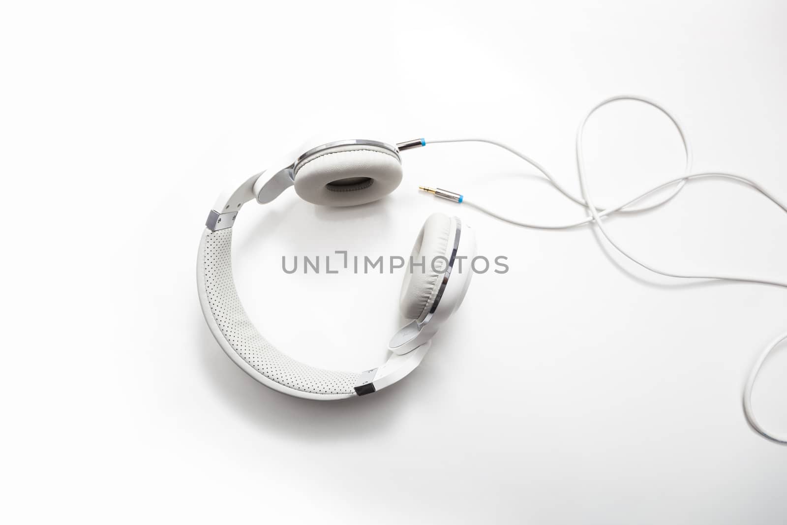 White headphones and Convention Aux cable 3.5 mm. Isolated on white background