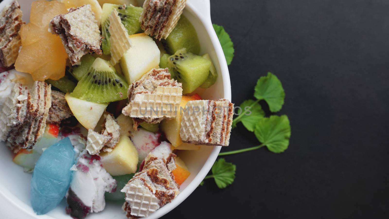 Close up desert with fresh fruit and ice cream. Mixed Fruit With with waffle and fruit ice on black background