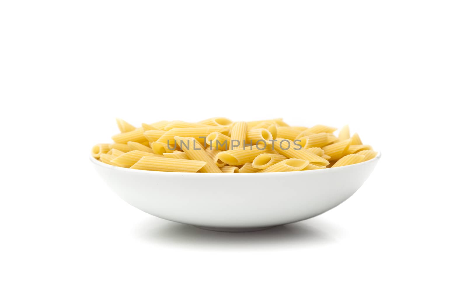 Pasta penne macaroni in bowl over isolated on a white background. Products from flour.