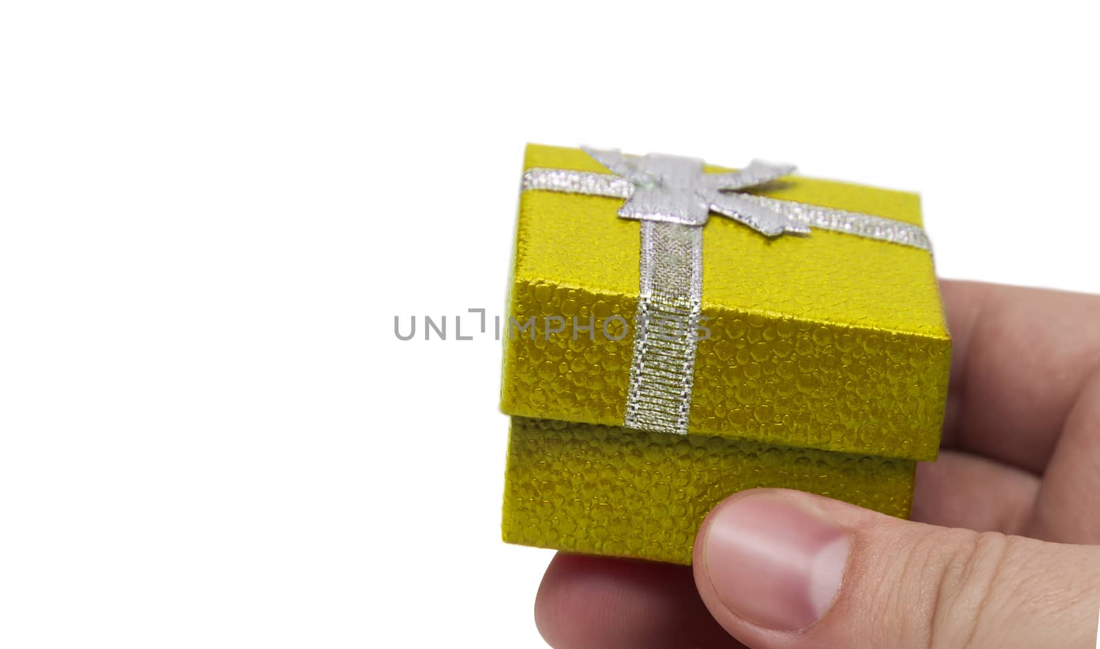 Hand holding small yellow collour gift with silver ribbon isolated on white background