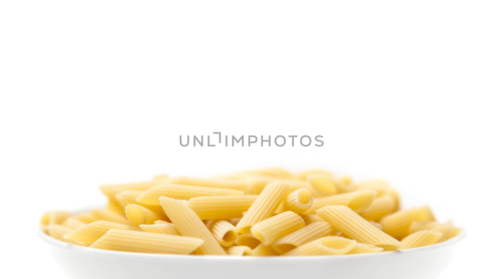Pasta penne macaroni in bowl over isolated on a white background. Products from flour.