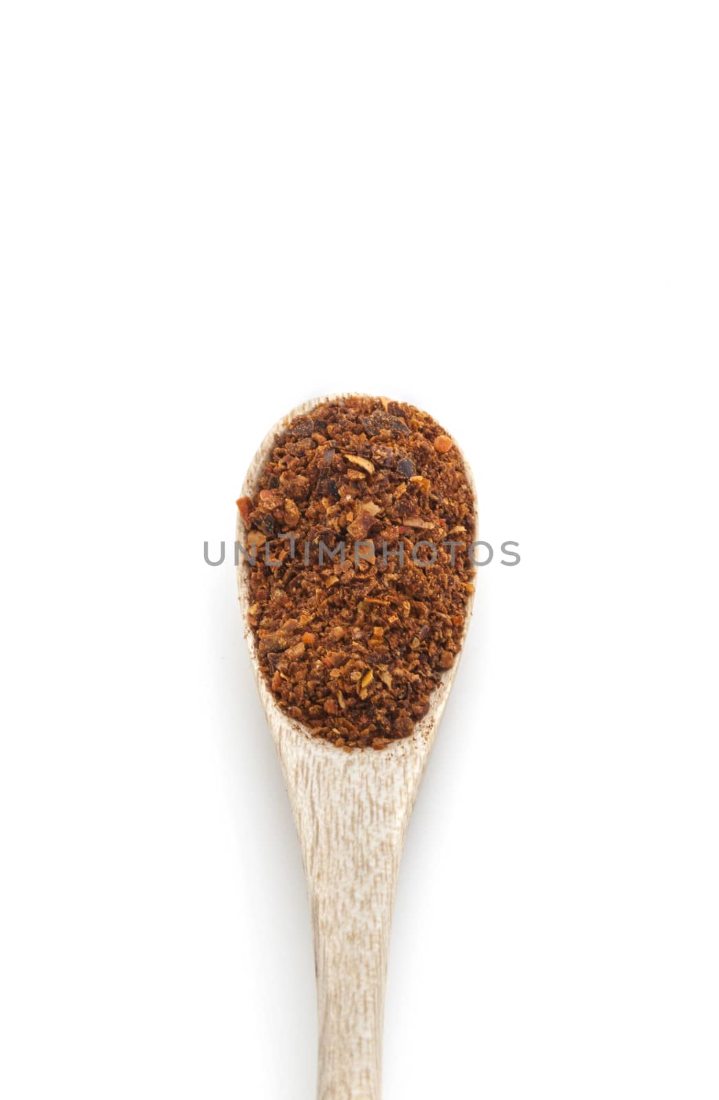 Ground red chili pepper paprika spice in wooden spoon isolated on white background