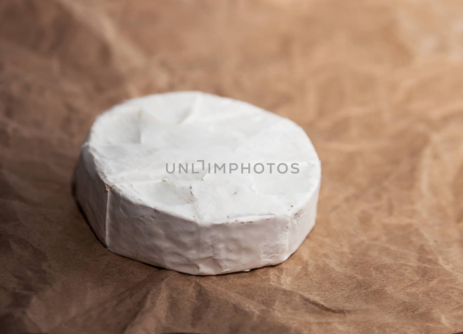 Fresh Camembert cheese is a natural, on Kraft paper brown background. With clipping path