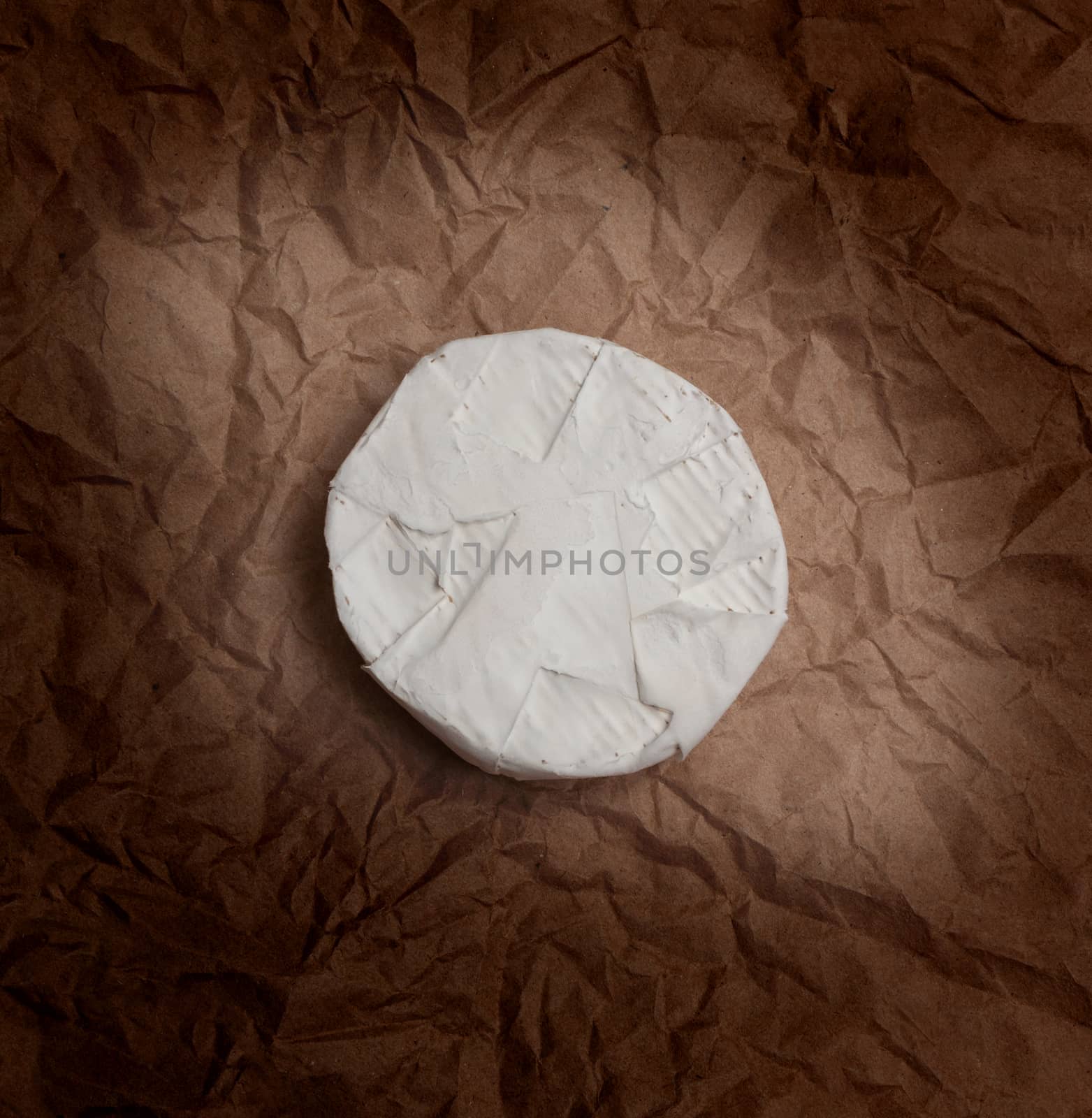 Fresh Camembert cheese is a natural, on Kraft paper brown background. With clipping path