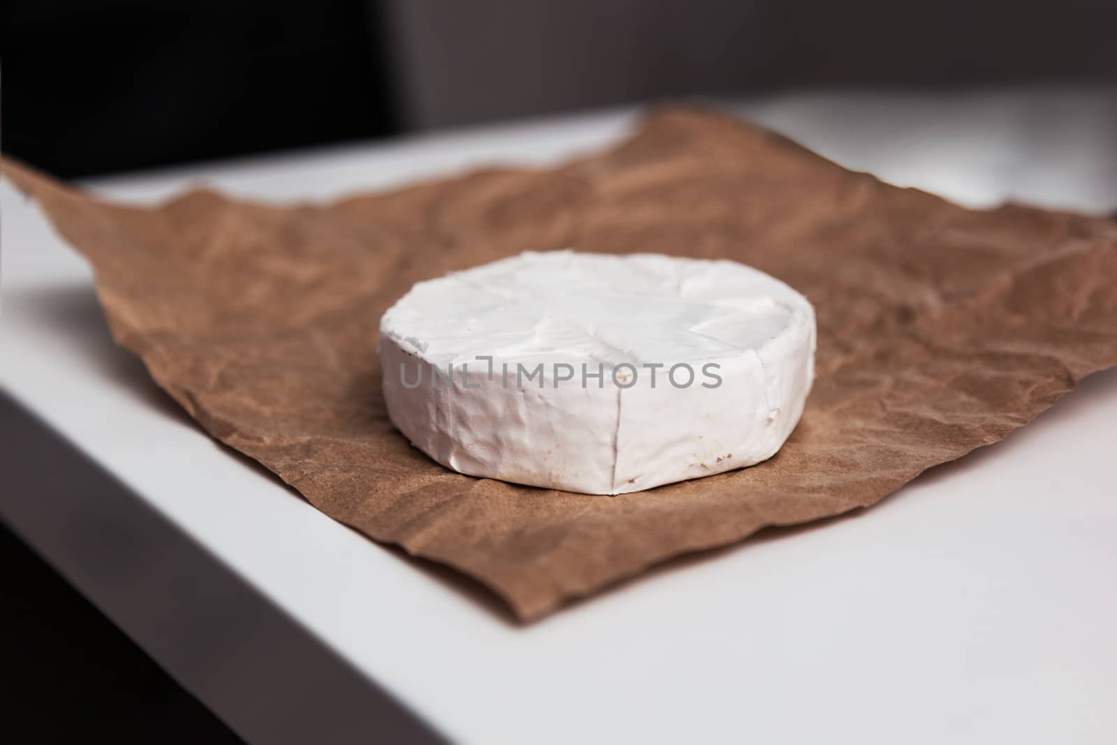 Fresh Camembert cheese is a natural, on Kraft paper brown background. With clipping path