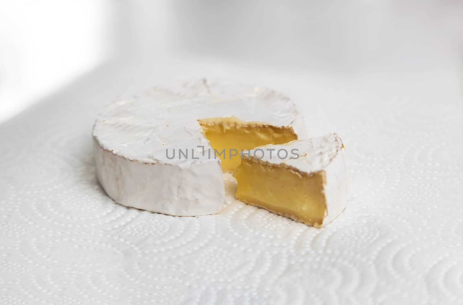 Fresh slice Camembert cheese natural, on white paper background. With clipping path