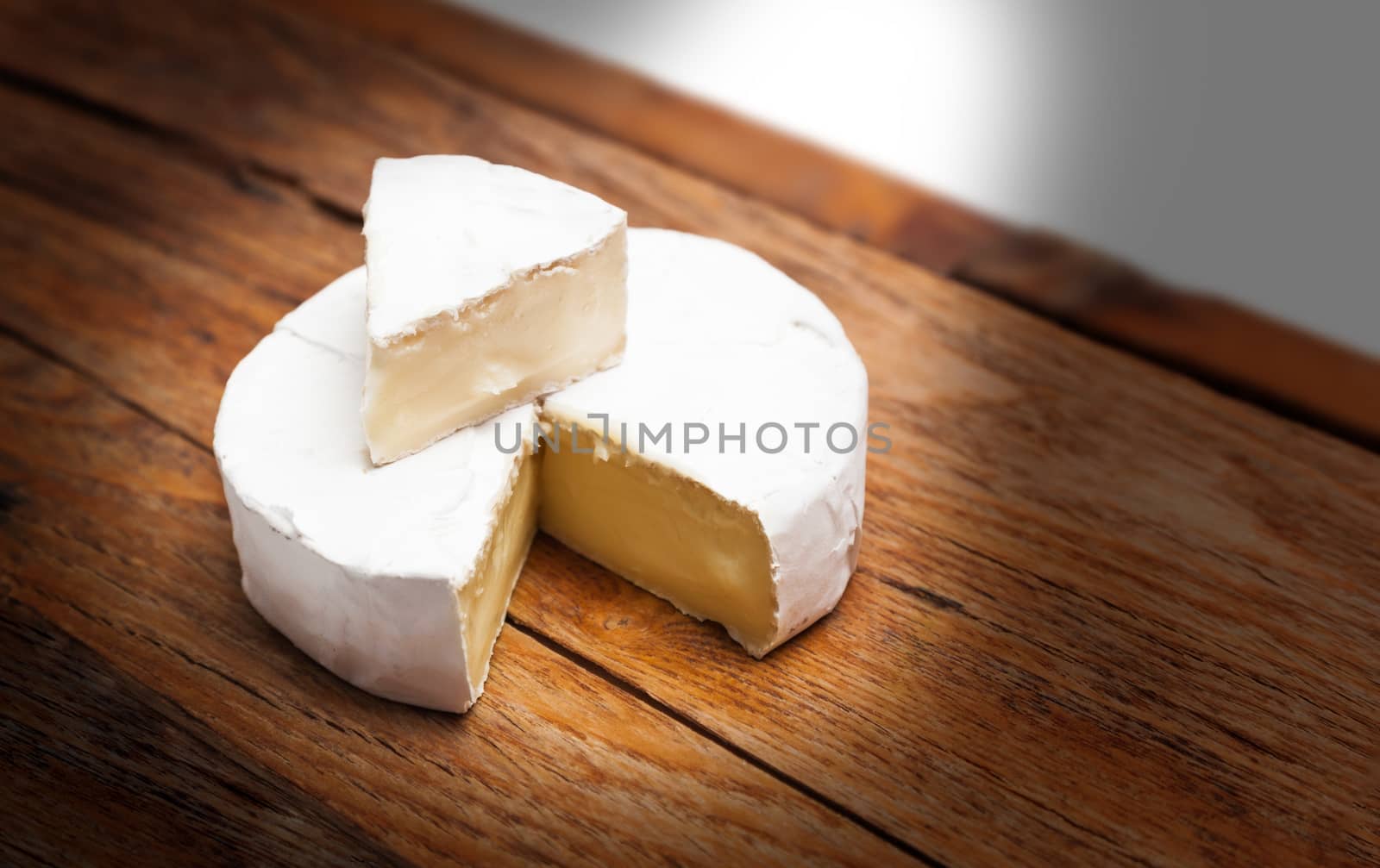 French Camembert cheese on rustic wooden table background