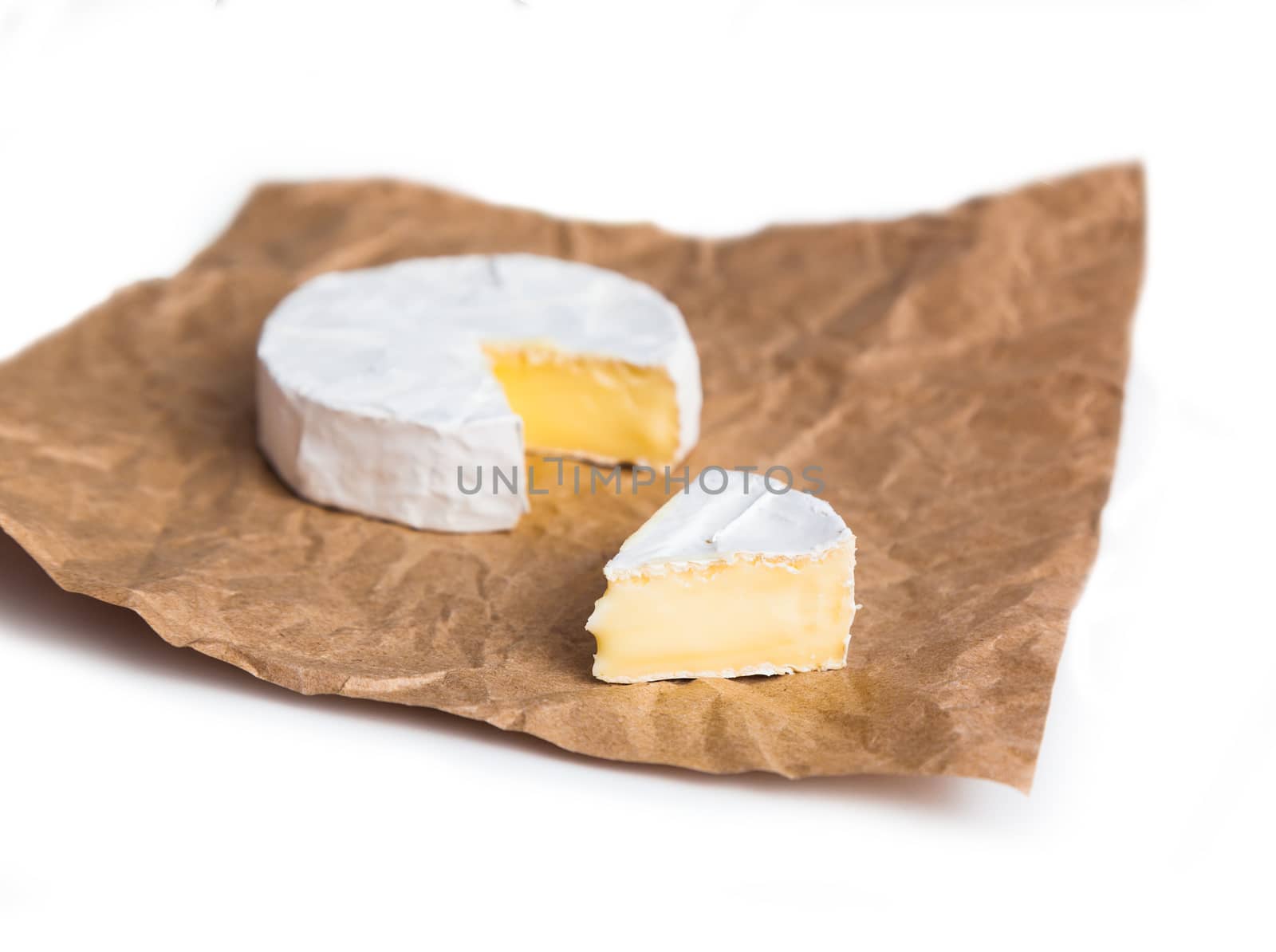 Fresh slice Camembert cheese natural, on Kraft paper brown background. With clipping path