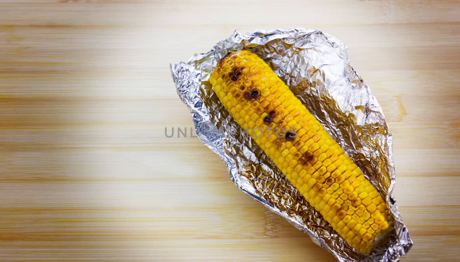 Tasty grilled corn on brown wooden table