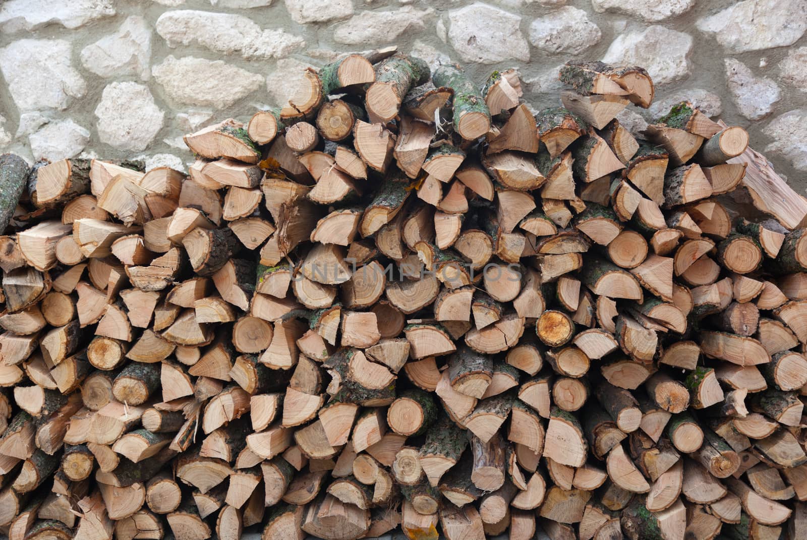 Firewood in a stone wall. Backgrounds and textures
