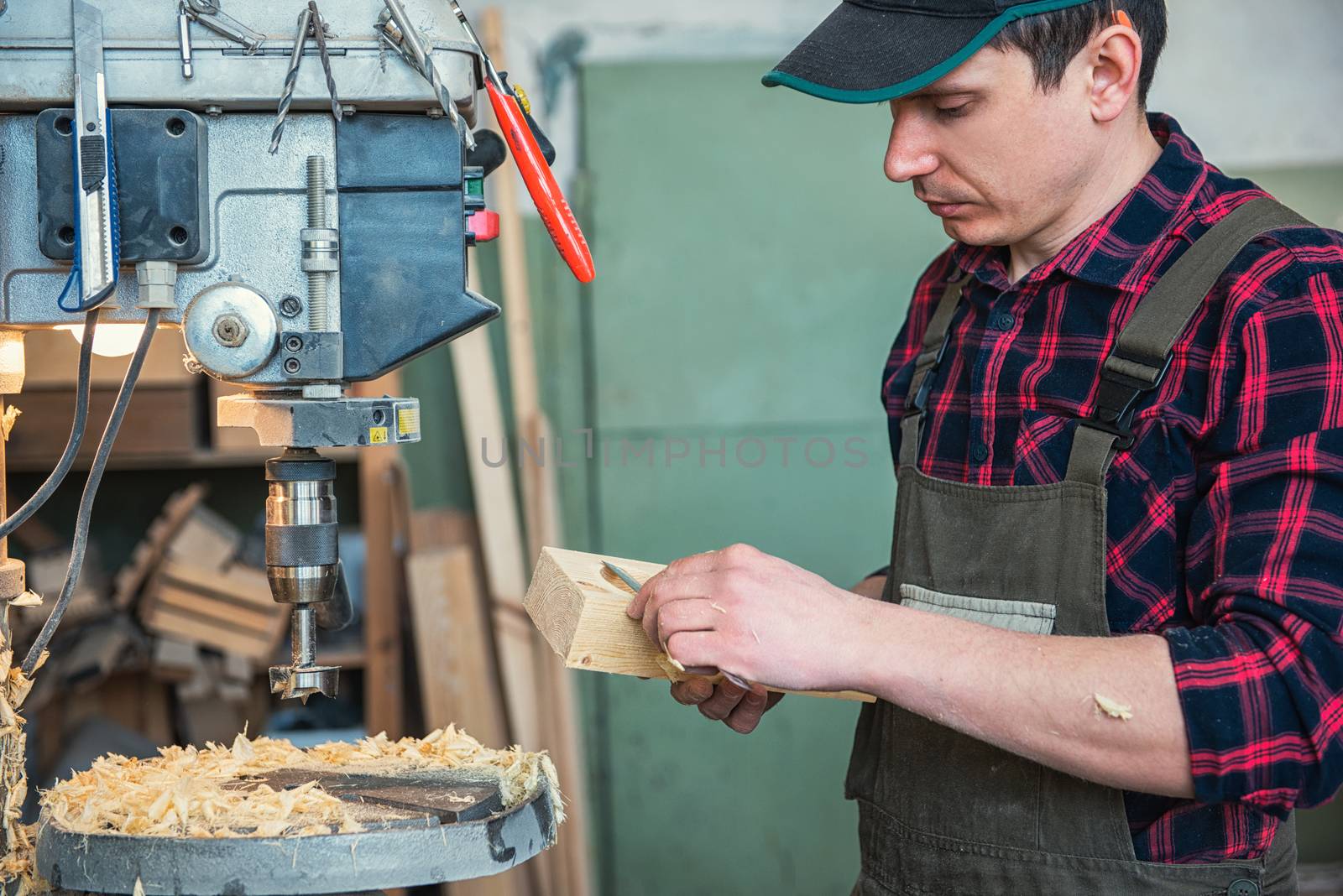 Worker grinds the wood box of angular grinding machine