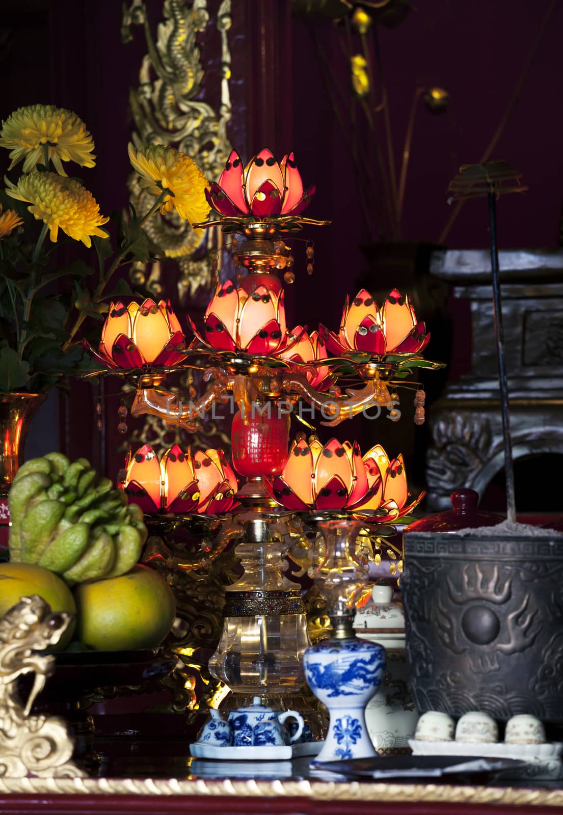 Gild lamp in a darkness of a buddhist Temple, Vietnam