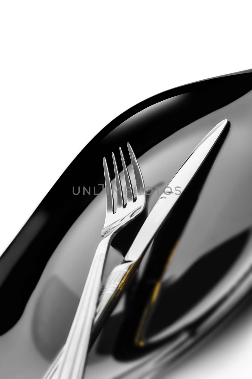 Knife and fork at plate on white background