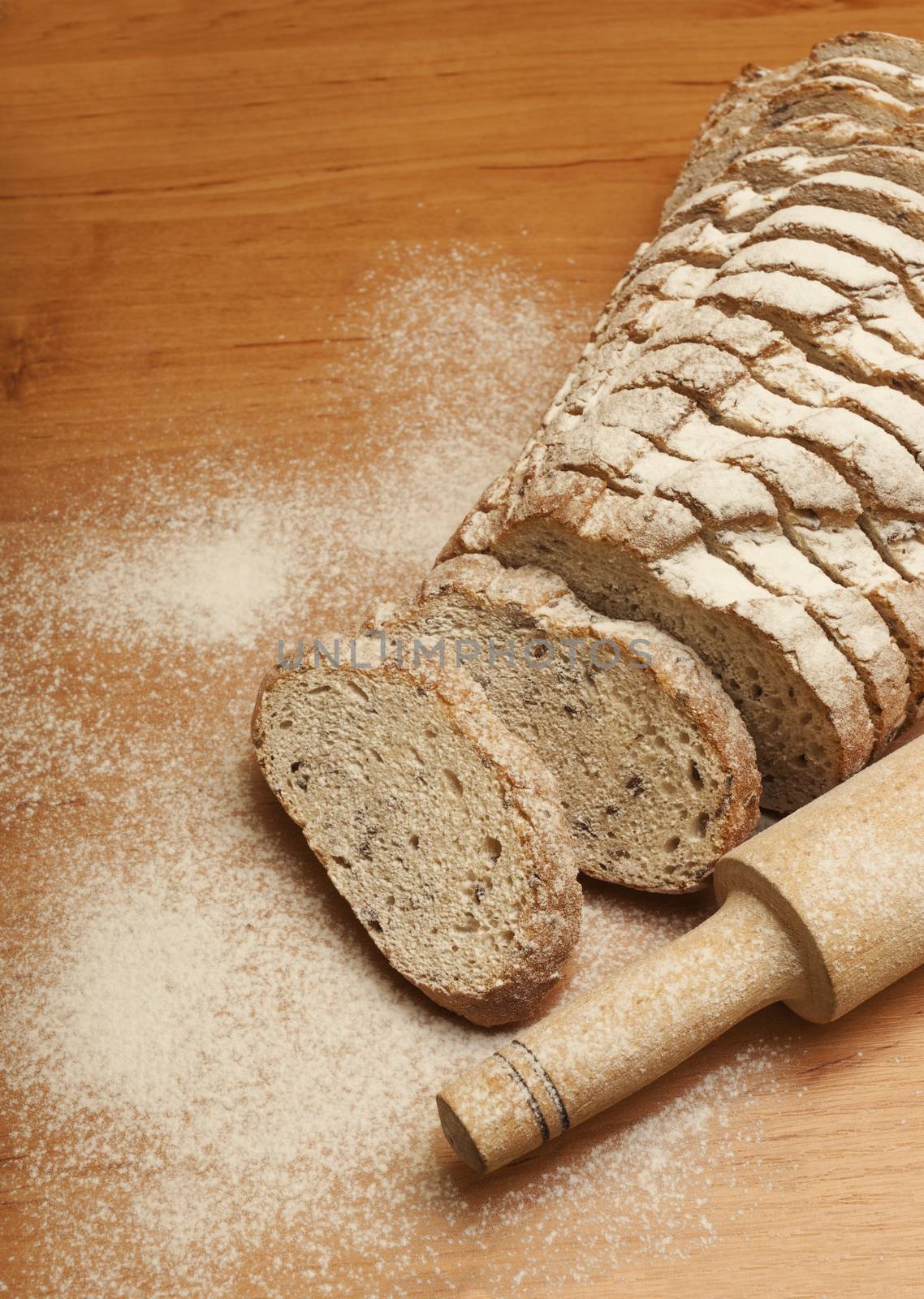 Sliced rye bread with linseed on wooden background.