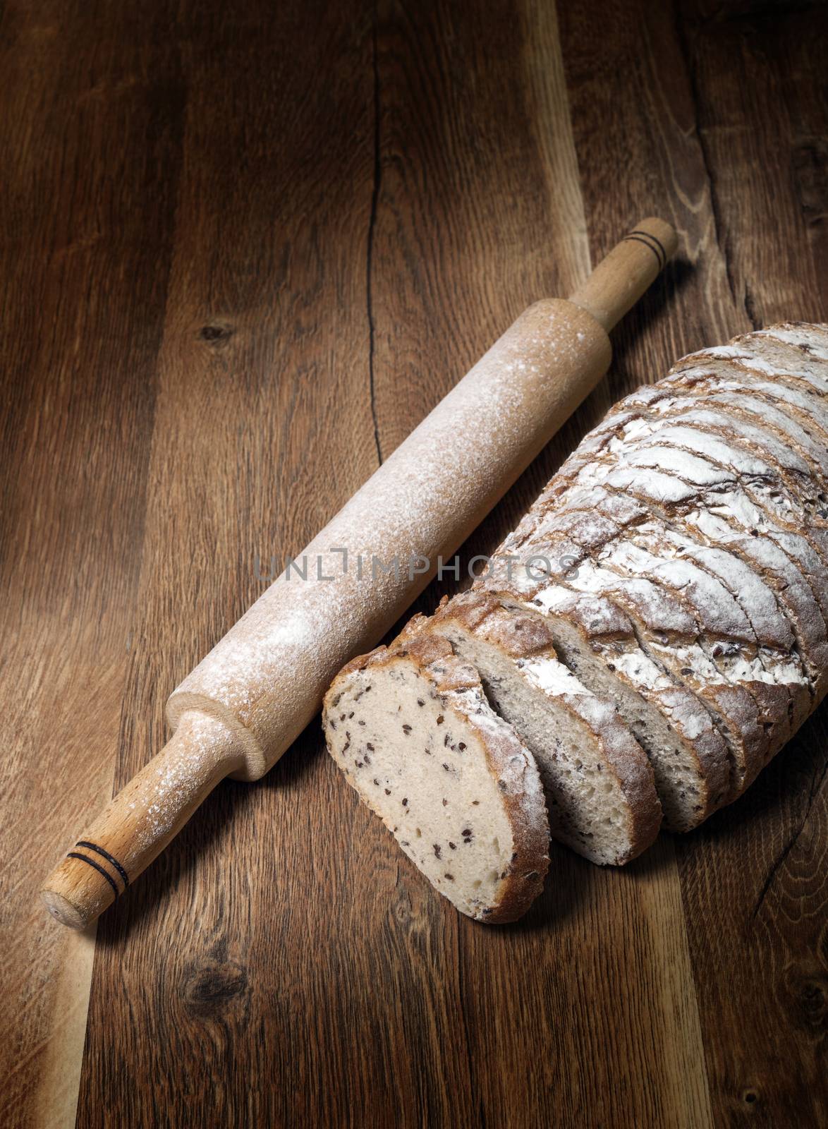 Sliced rye bread with linseed on wooden background.