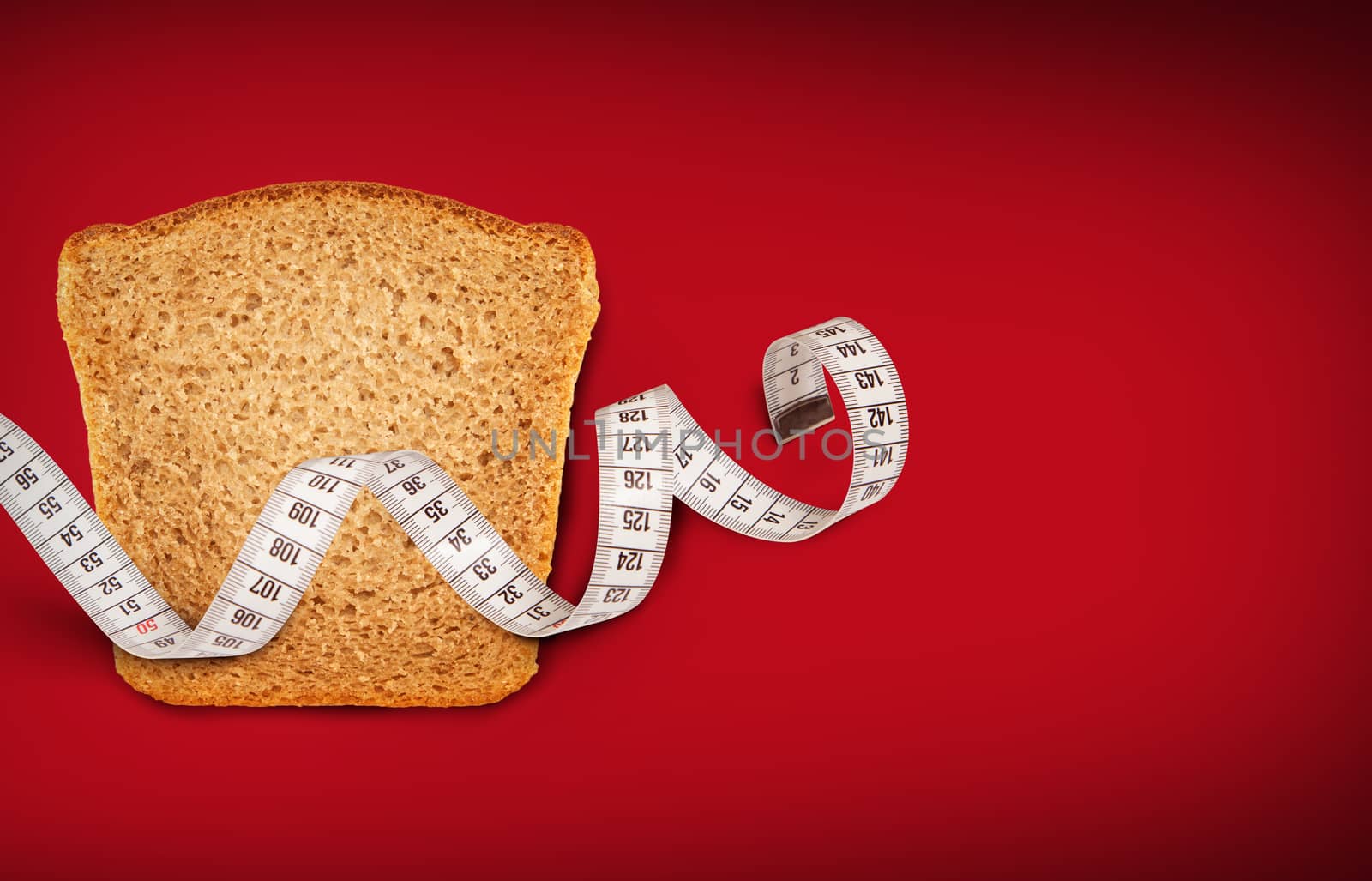 Wheat bread piece with the measuring tape on red background. Concept of health care.
