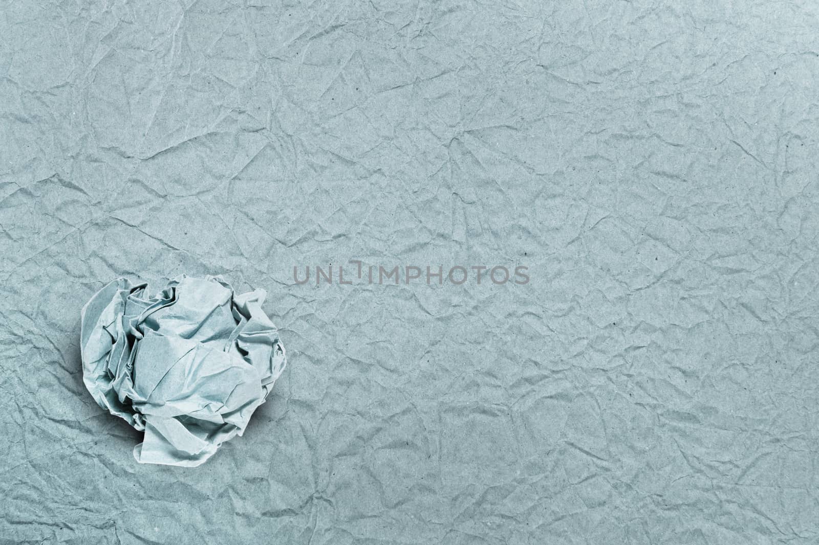 Crumpled paper ball on crumpled paper, for backgrounds or textures
