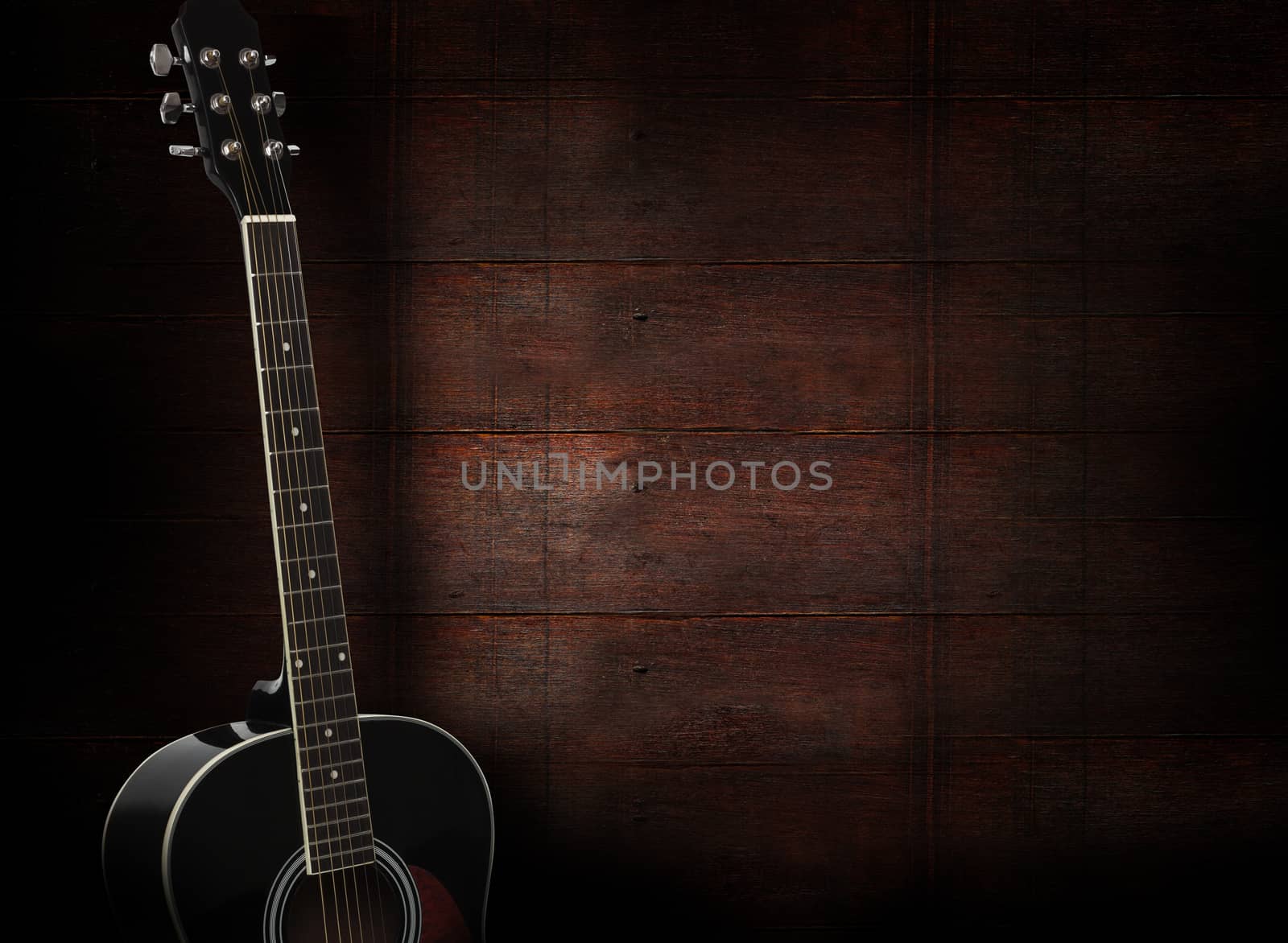 Black acoustic guitar on dark red wooden background.