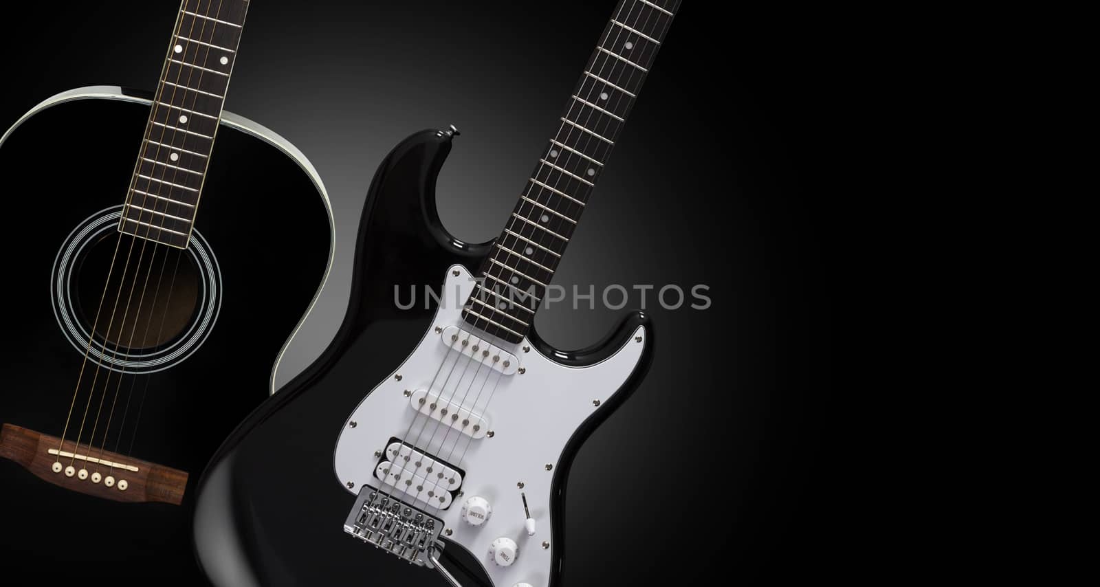 Black acoustic and electric guitars on a black background.
