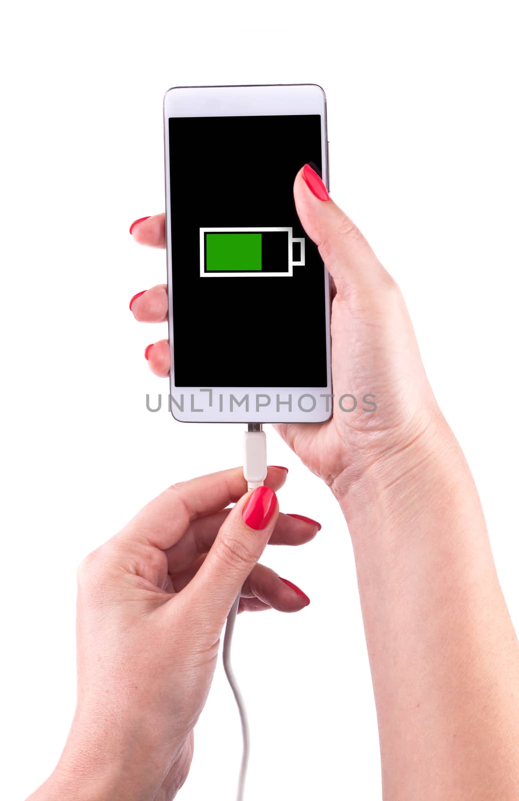 Female hand holding a smartphone and connecting charger, isolated on white background