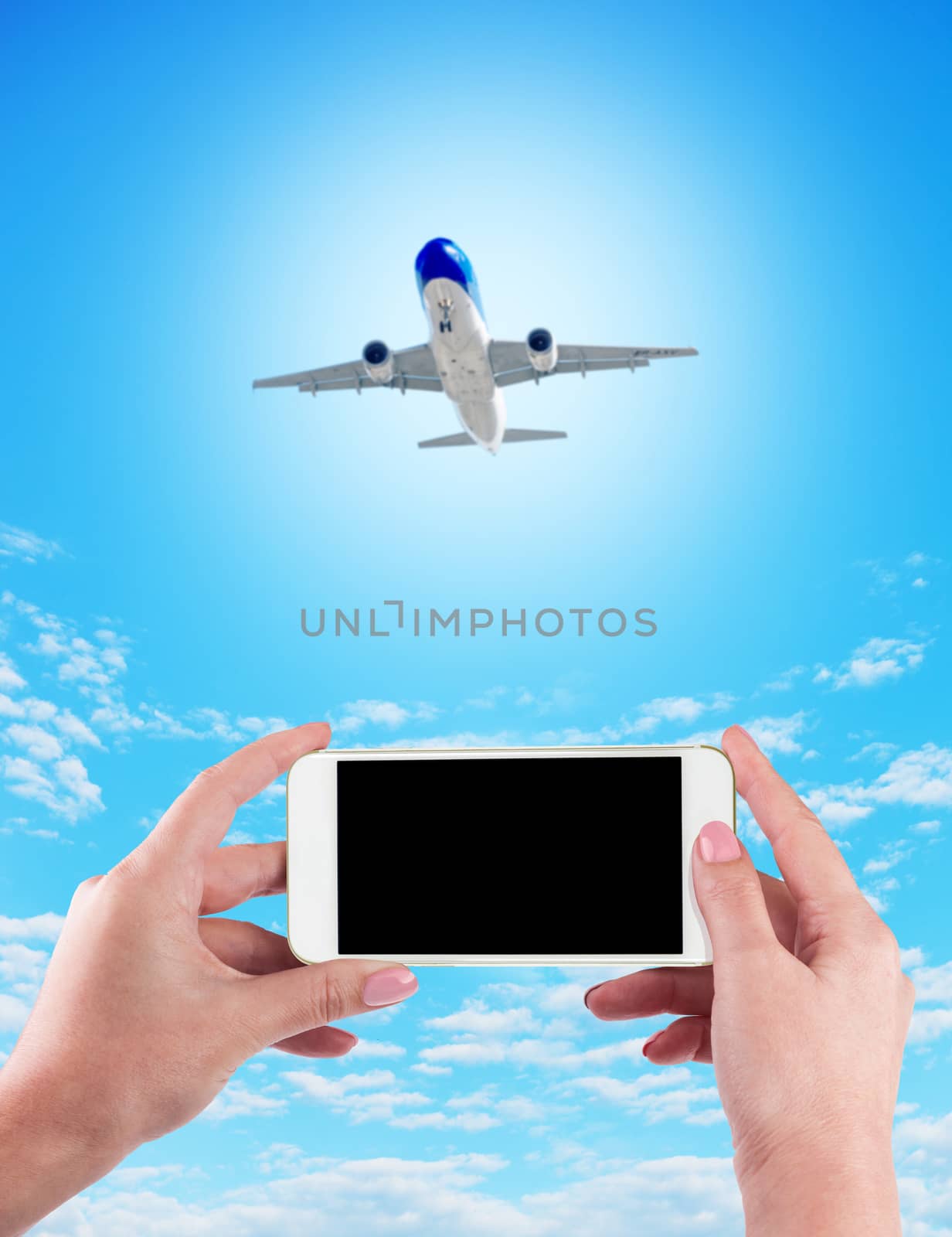 Female Hand holding using mobile phone and airplane on a blue background