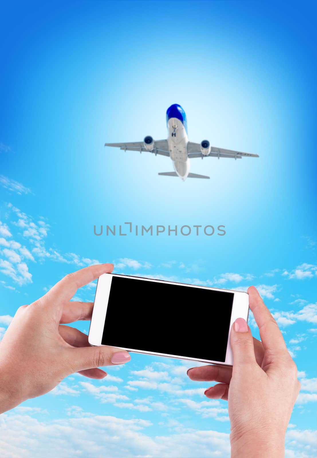 Female Hand holding using mobile phone and airplane on a blue background