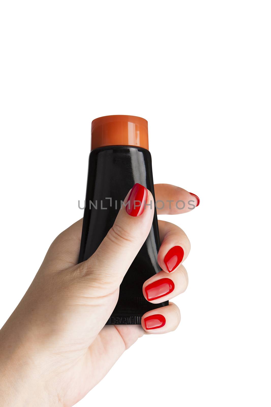 Black plastic tube for cosmetics and body care in a female hand, isolated. Isolated on blue background. With clipping path