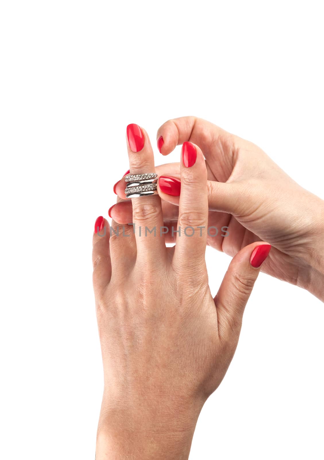 Female hands with red manicure wears a silver ring, isolated on white background