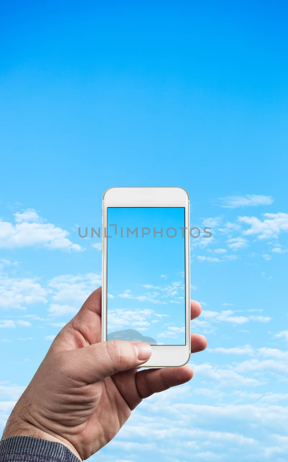 Man Hand holding mobile phone photographing blue sky with clouds