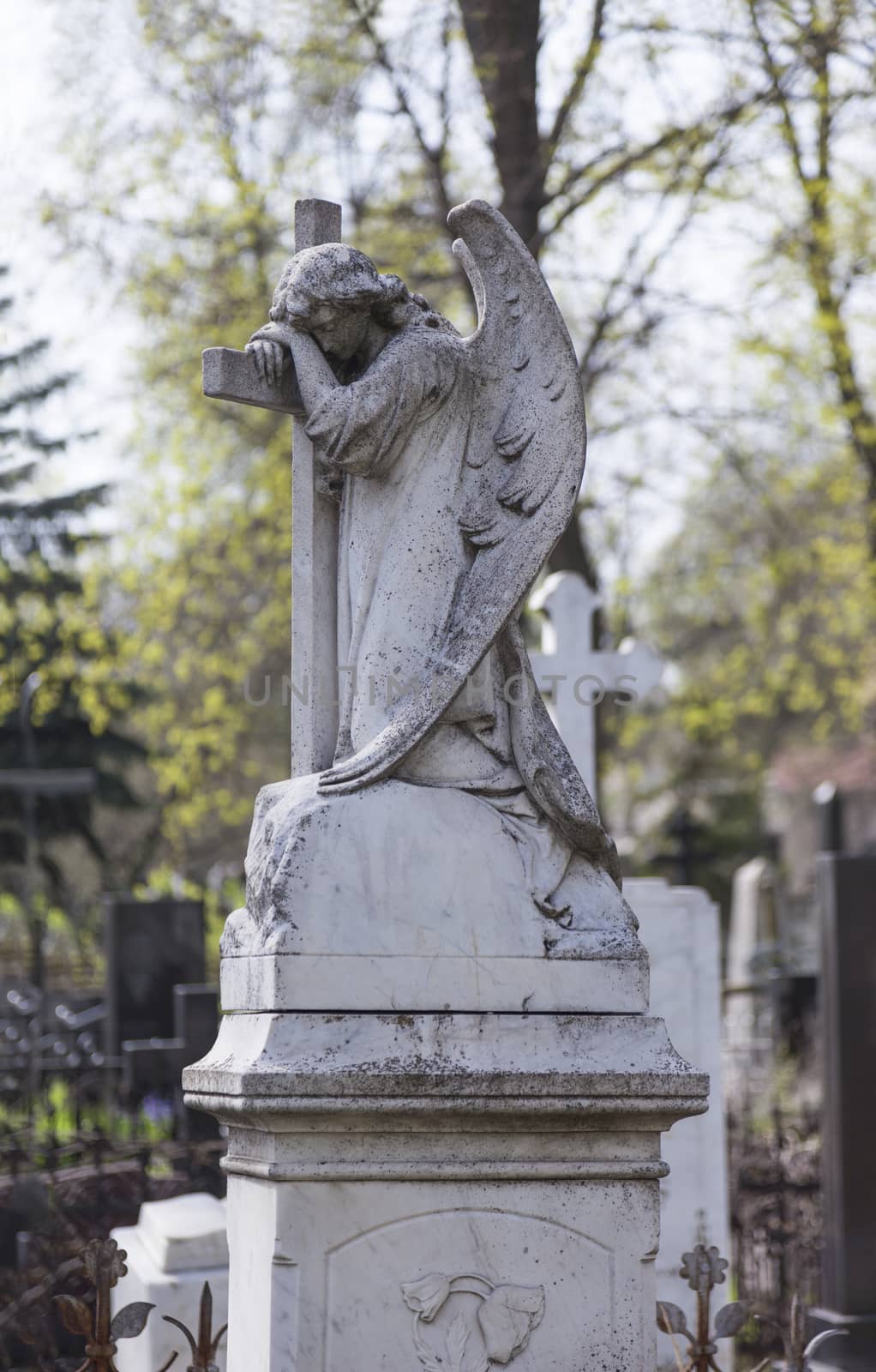 Angel and cross monument on a very old grave.