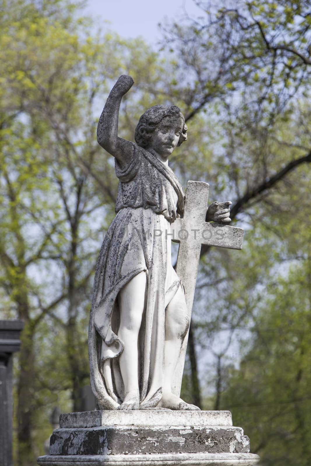 Angel and cross monument on a very old grave.