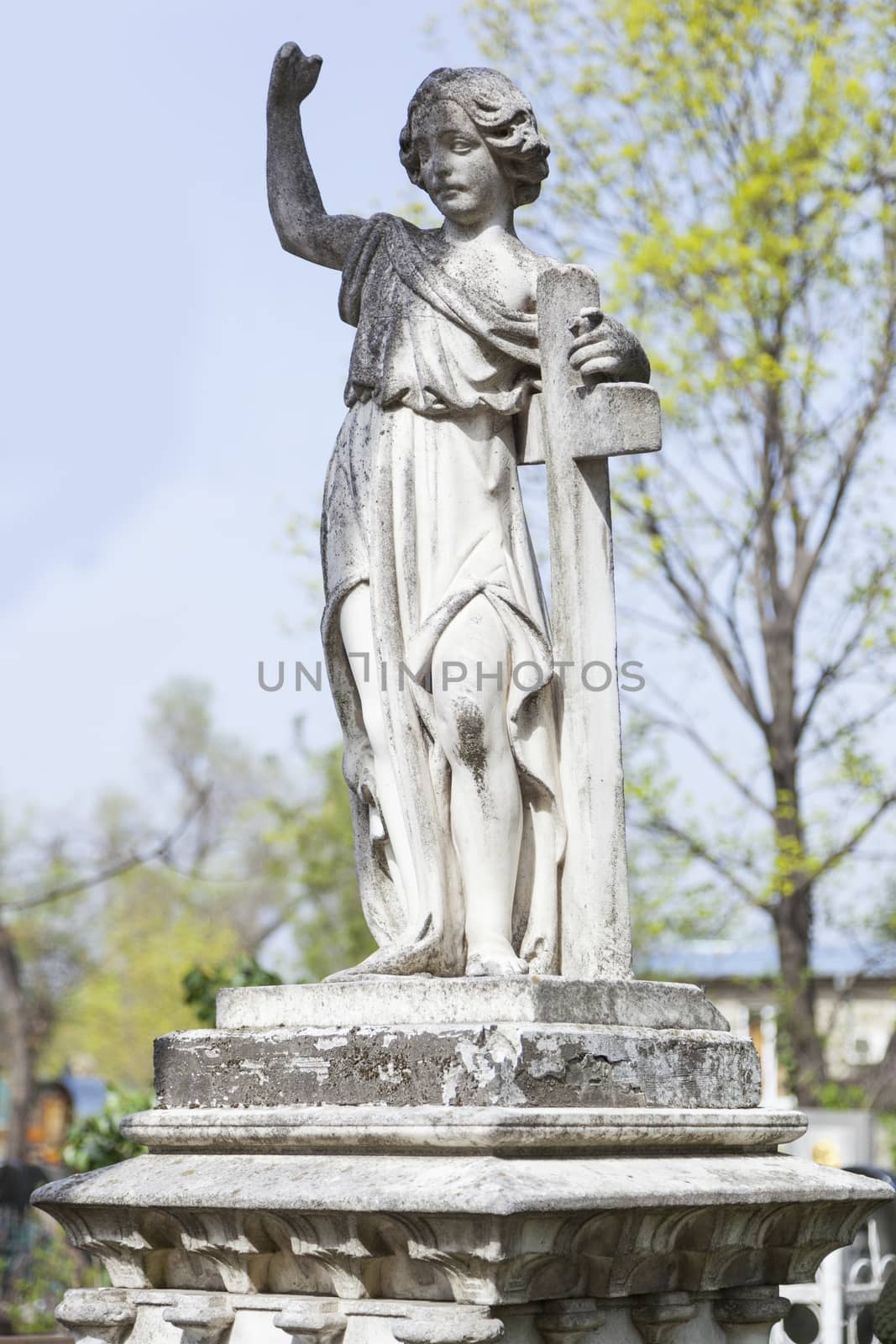 Angel and cross monument on a very old grave.