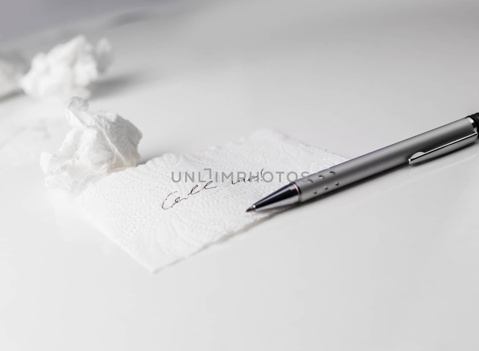 Napkin With Scribbled text, paper ball and Pen on Table on white background
