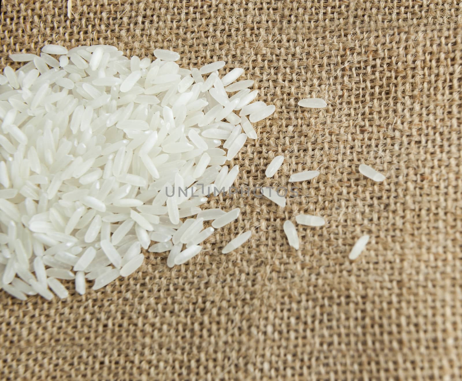 Asian uncooked white rice on a background of rough cloth
