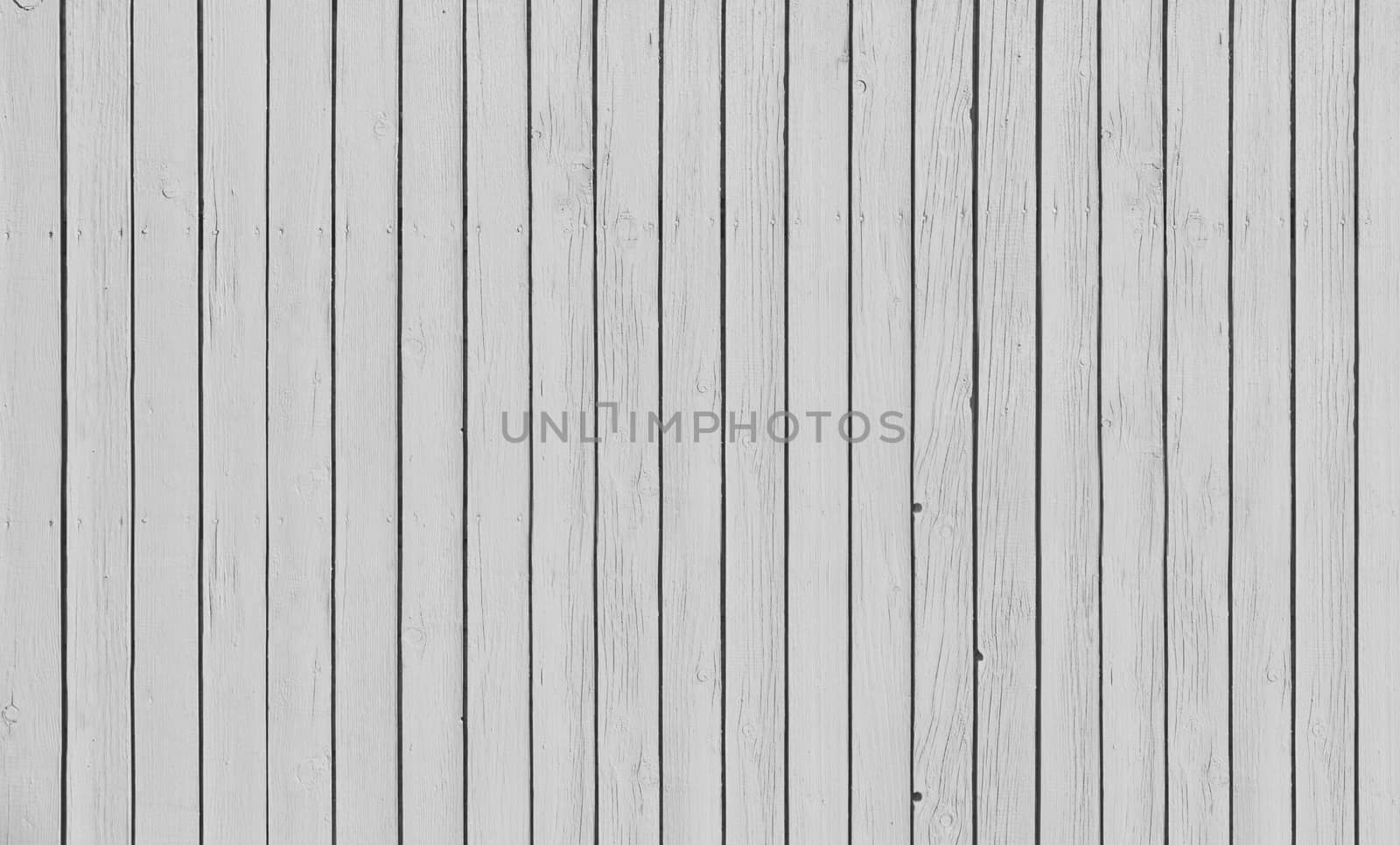 Wooden slat fence with parallel planks with white paint.