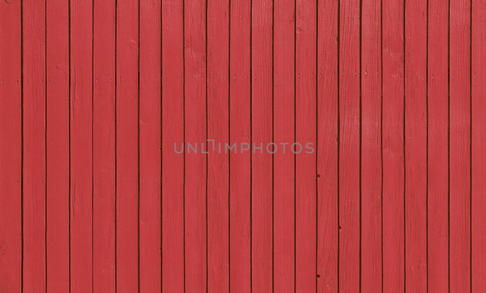 Wooden slat fence with parallel planks with red paint.