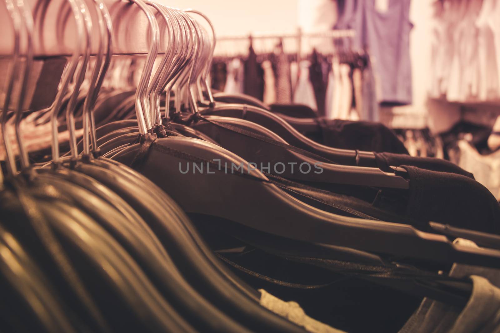 Close up of many clothes on hangers in a clothing shop.