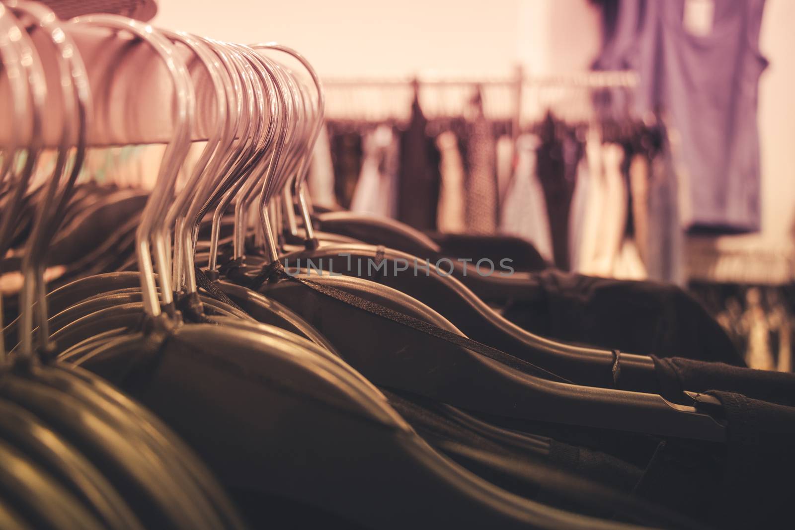 Close up of many clothes on hangers in a clothing shop.