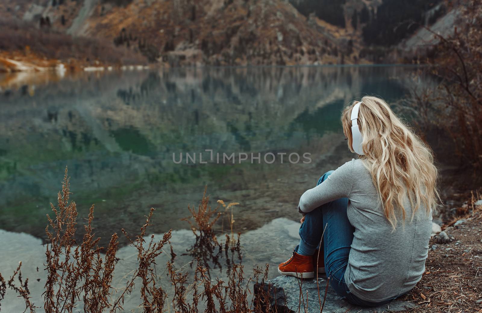 Woman wearing wireless headshot at the mountain lake by Novic
