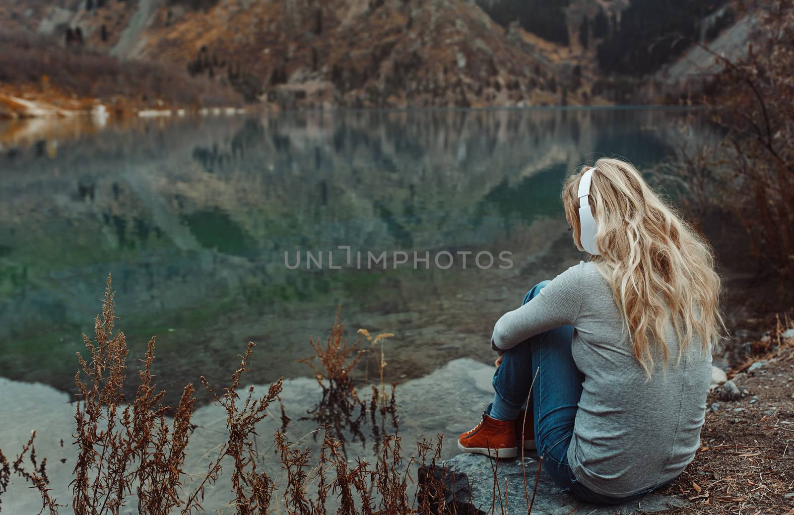 Woman wearing wireless headshot at the mountain lake