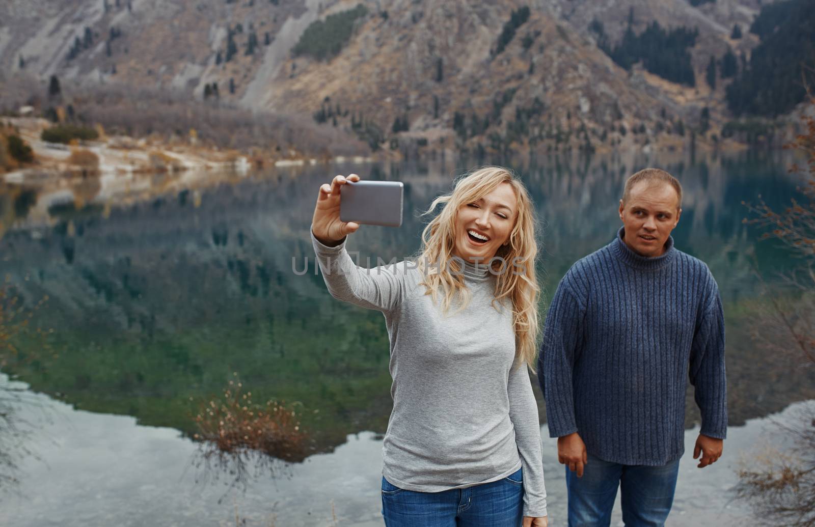 Couple making selfie at the mountain lake