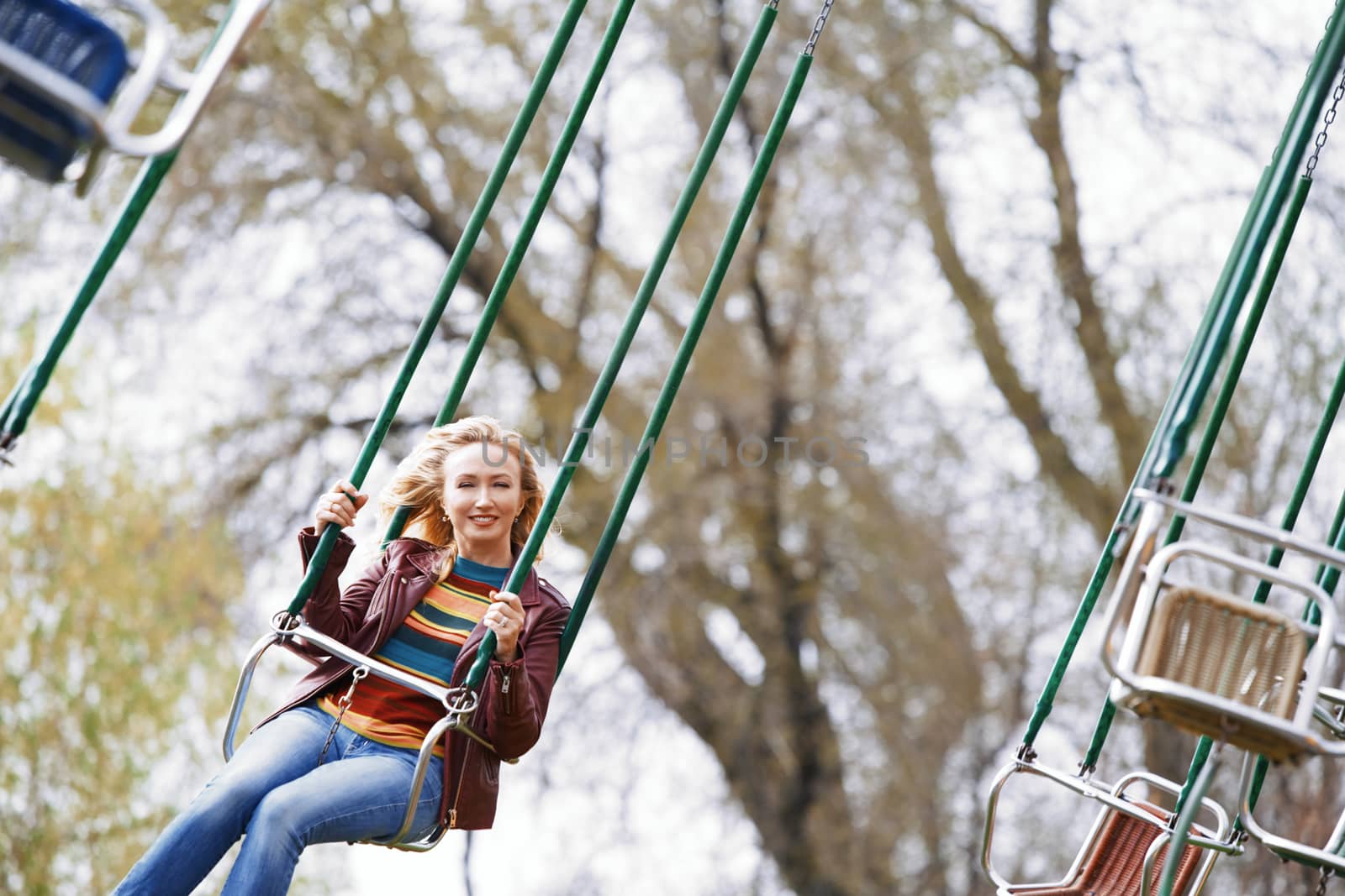 Blond woman riding on a chain swing