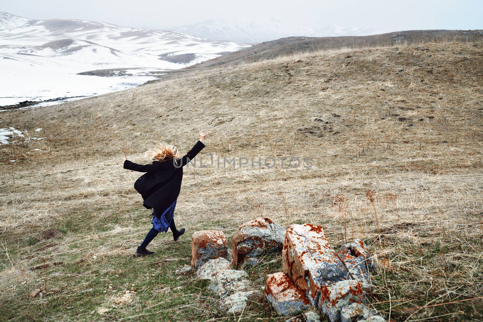 Woman running away in the snow landscape by Novic